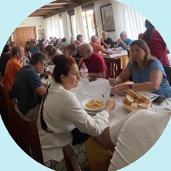Pilgrims sharing a long-table meal
